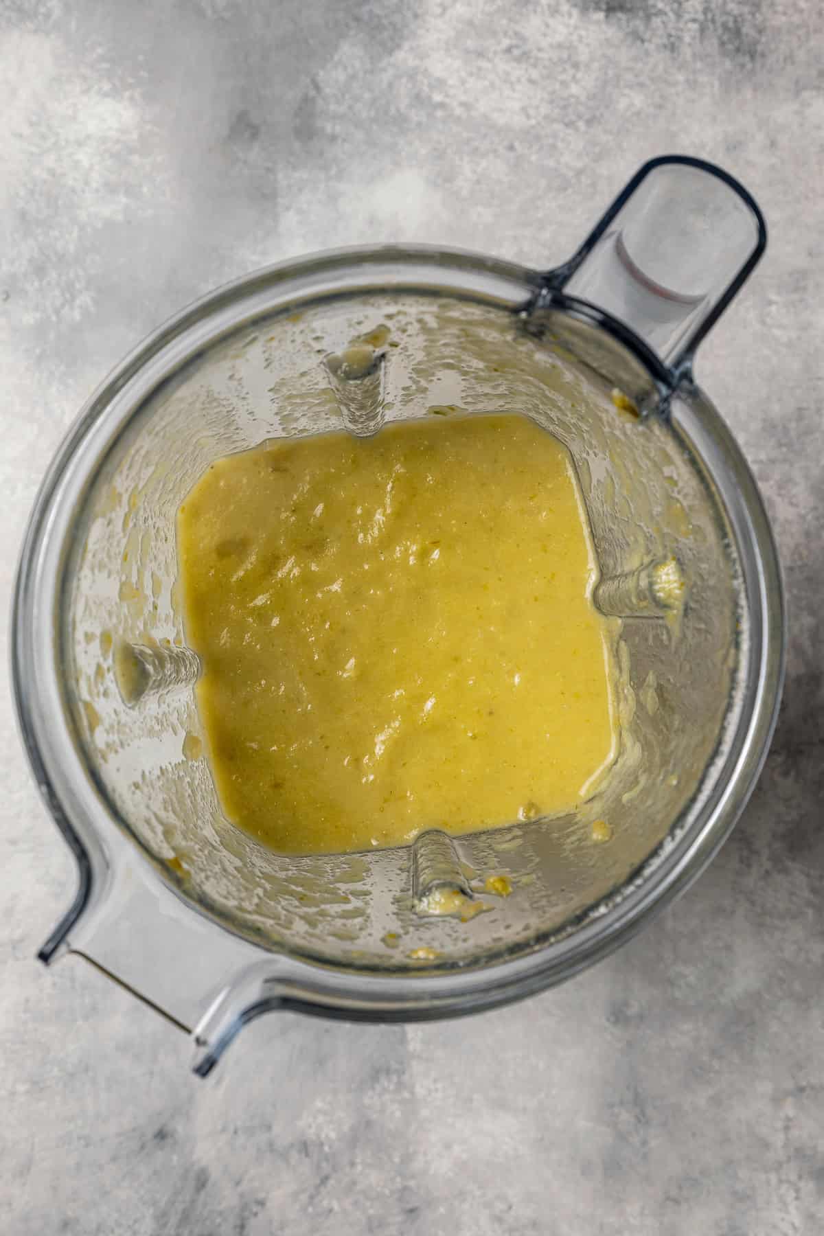 Pureed green chili sauce inside a blender.