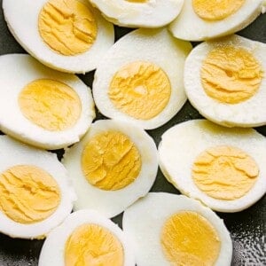 boiled eggs cut in half and set on a black plate