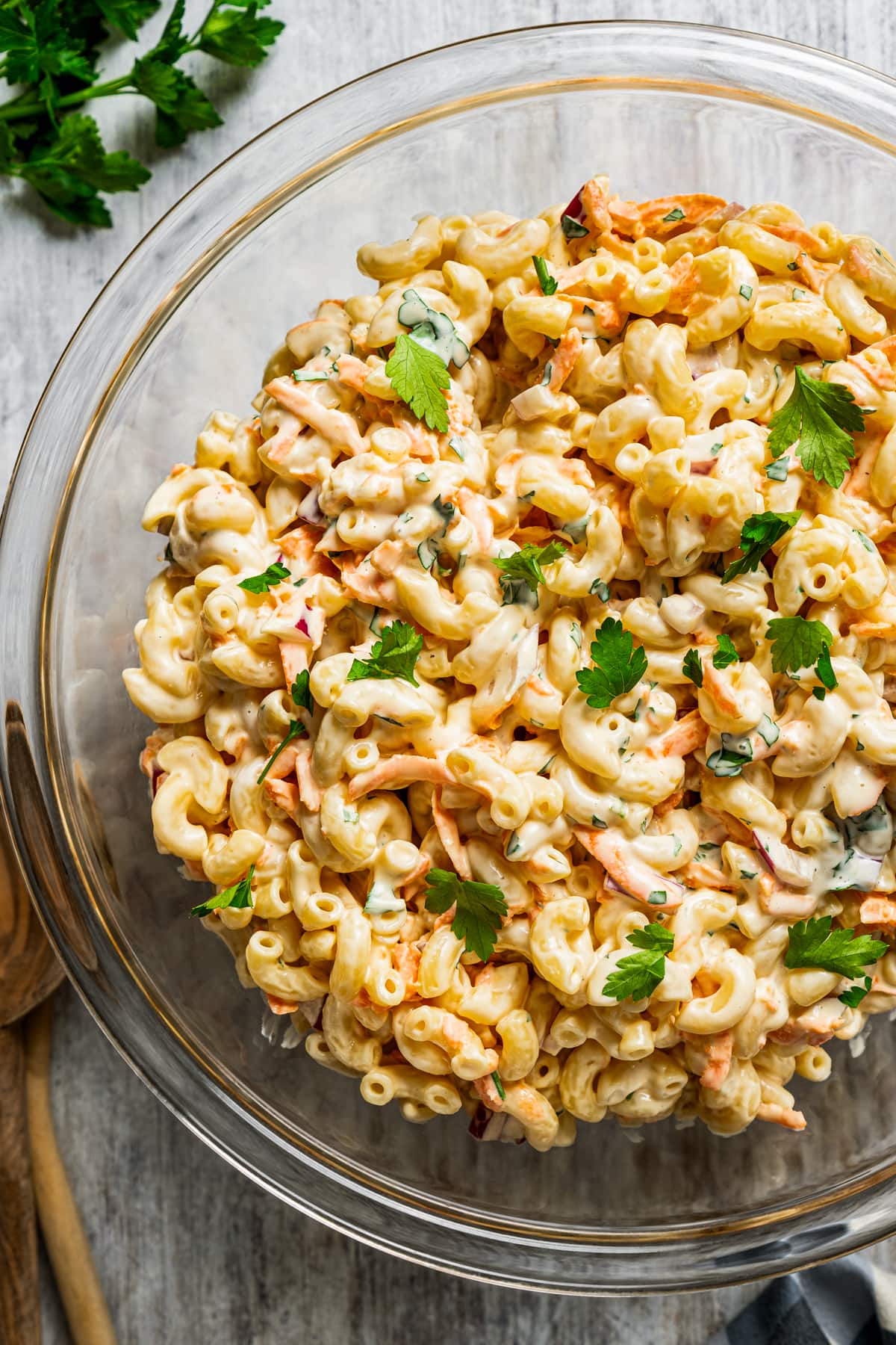 Pasta salad in a glass mixing bowl.