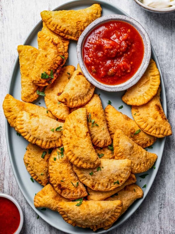 A plate with homemade Pierogi and dipping sauce.