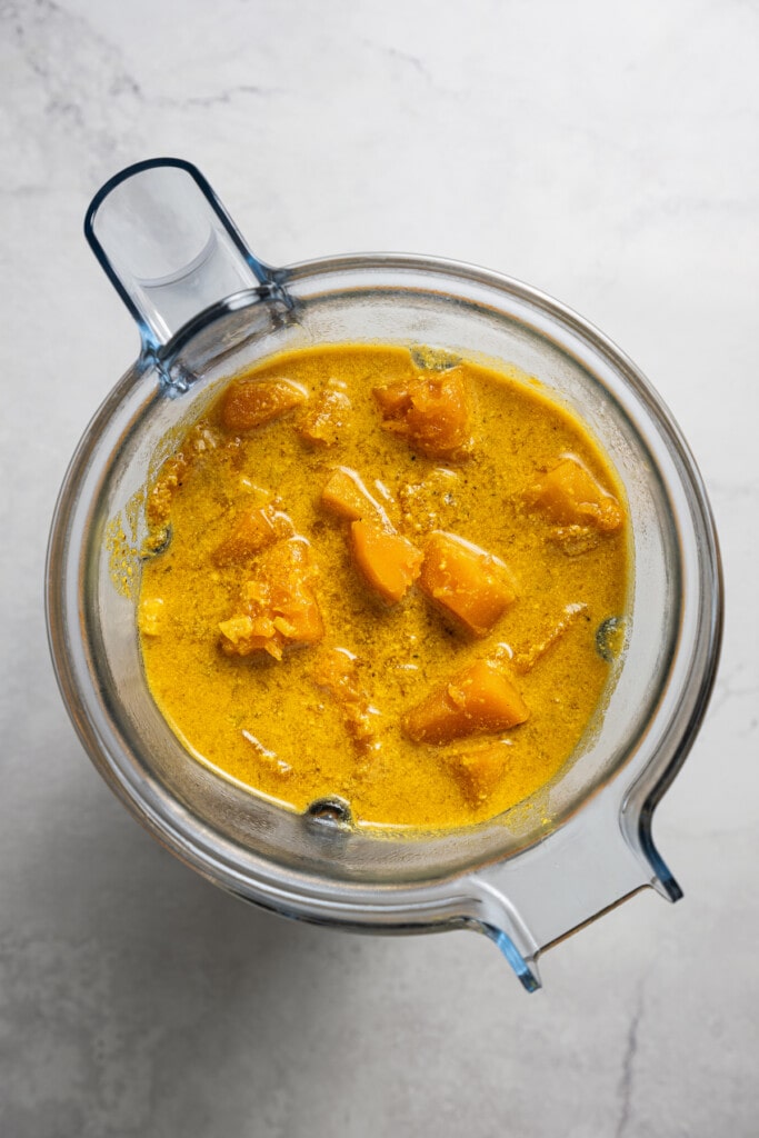 Adding unblended butternut squash soup to a blender.