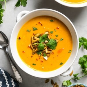 Overhead image of two bowls of soup garnished with pepitas.