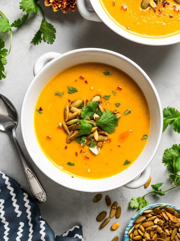 Overhead image of two bowls of soup garnished with pepitas.