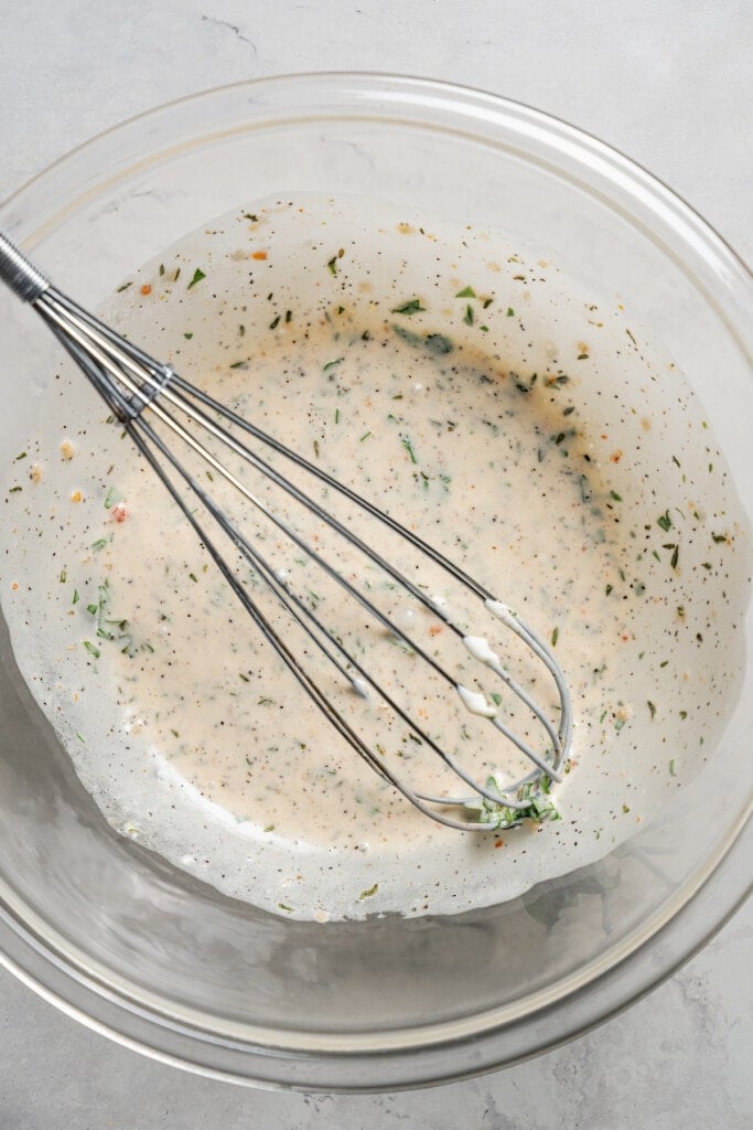 Whisking together Italian dressing marinade.