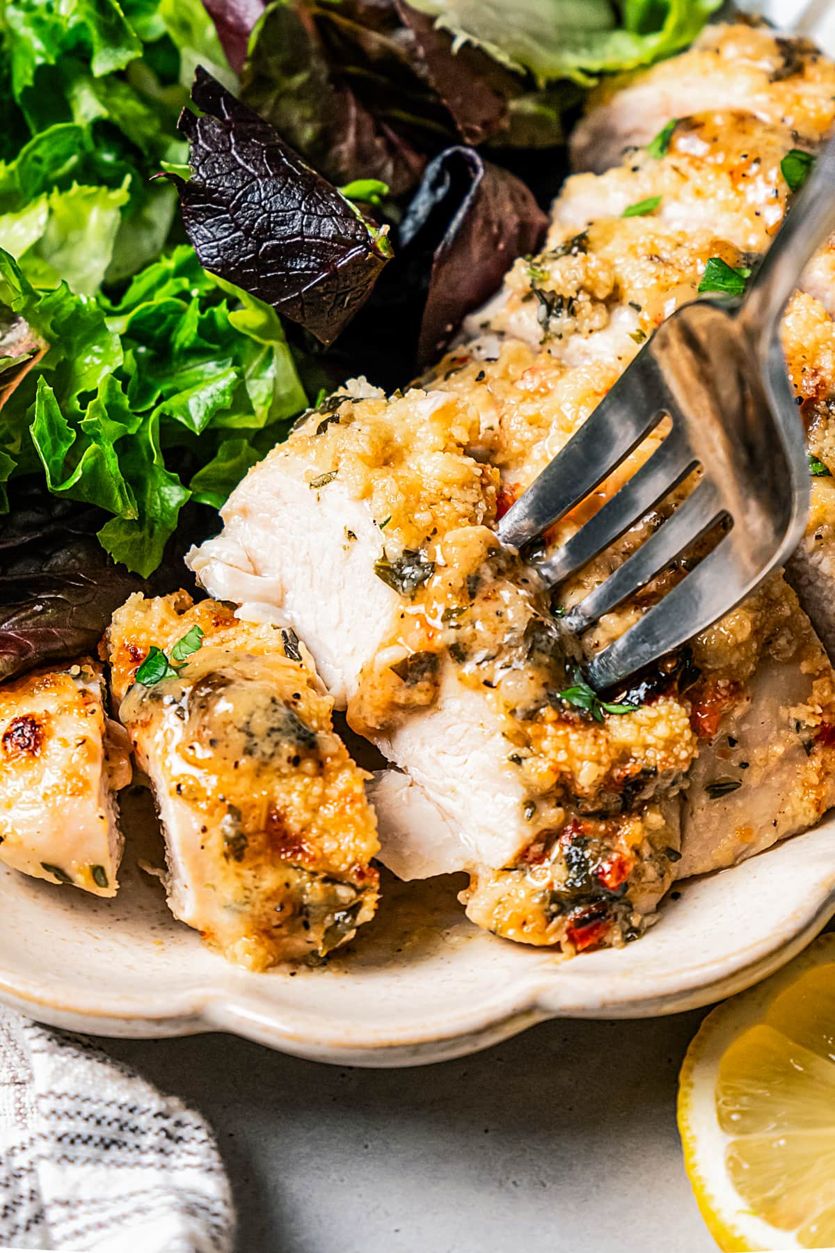 A fork taking a bite out of Italian dressing chicken.