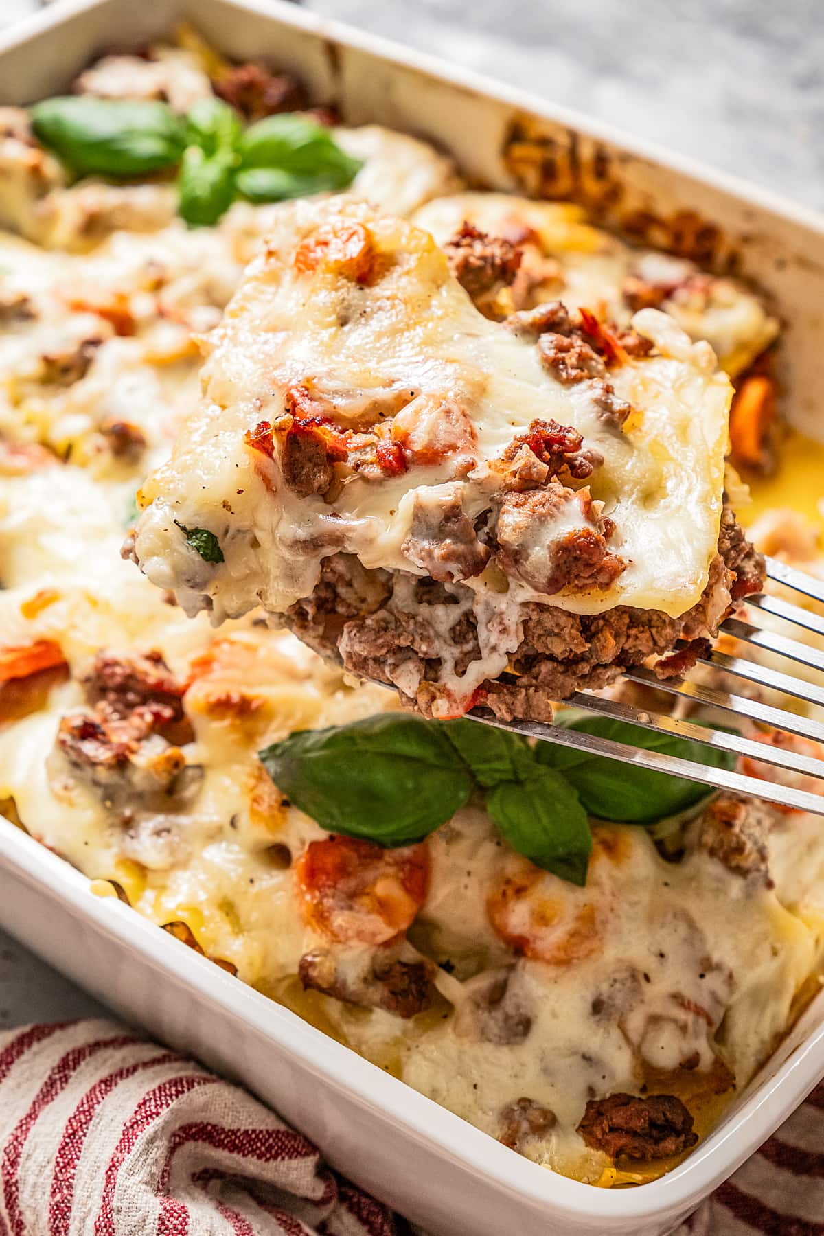 Taking a slice of lasagna bolognese out of the lasagna pan.