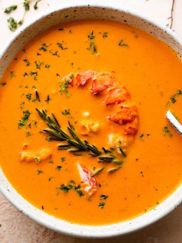 soup bowl with lobster bisque garnished with lobster meat and rosemary