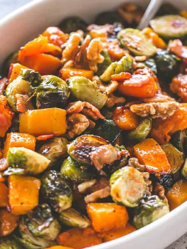 Close-up image of Maple Glazed Roasted Butternut Squash with Brussels Sprouts served in a white dish.