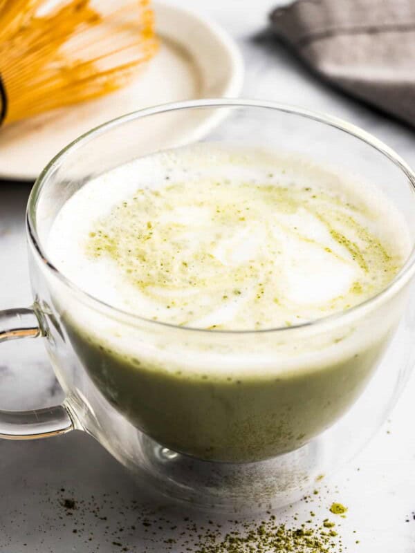 Warm matcha latte in a clear glass mug.