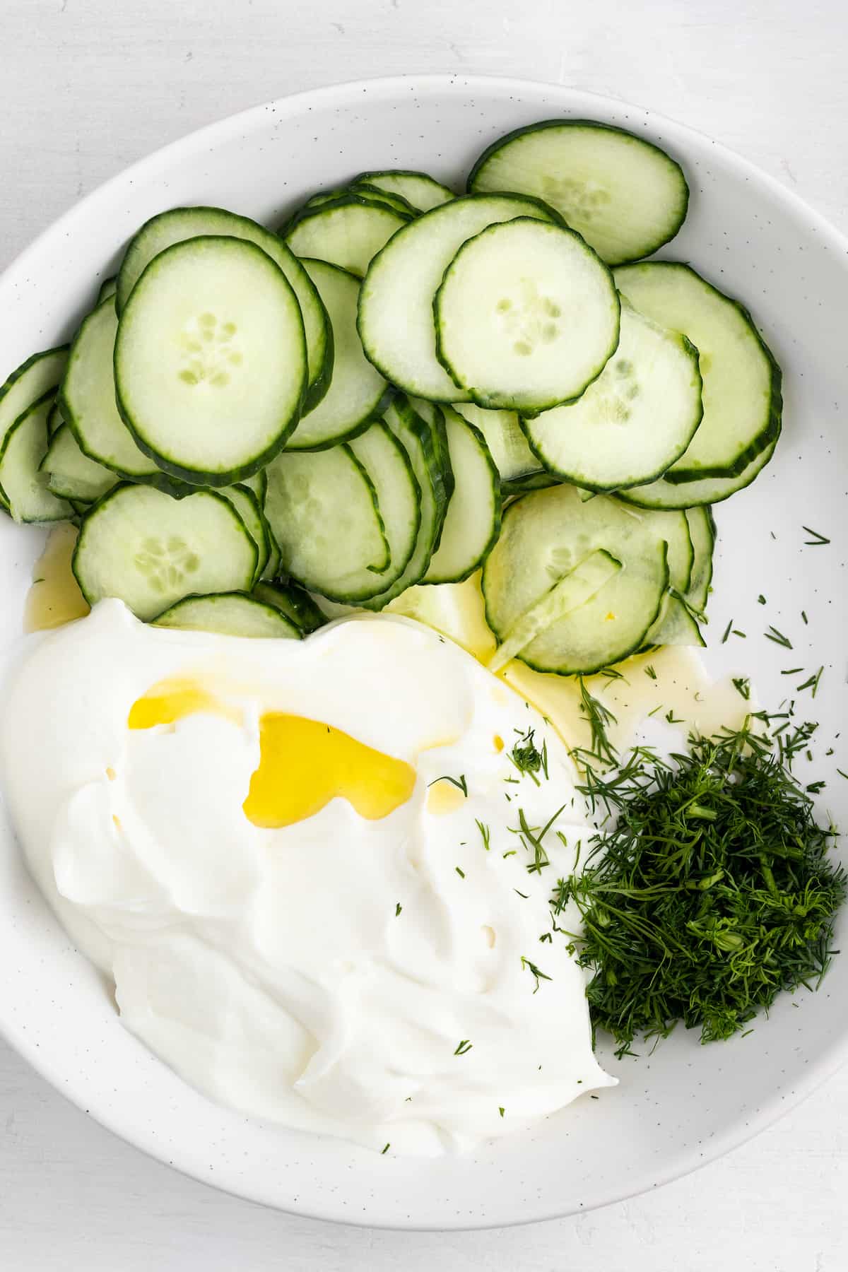 Ingredients for tzatziki in a bowl ready to be mixed together.