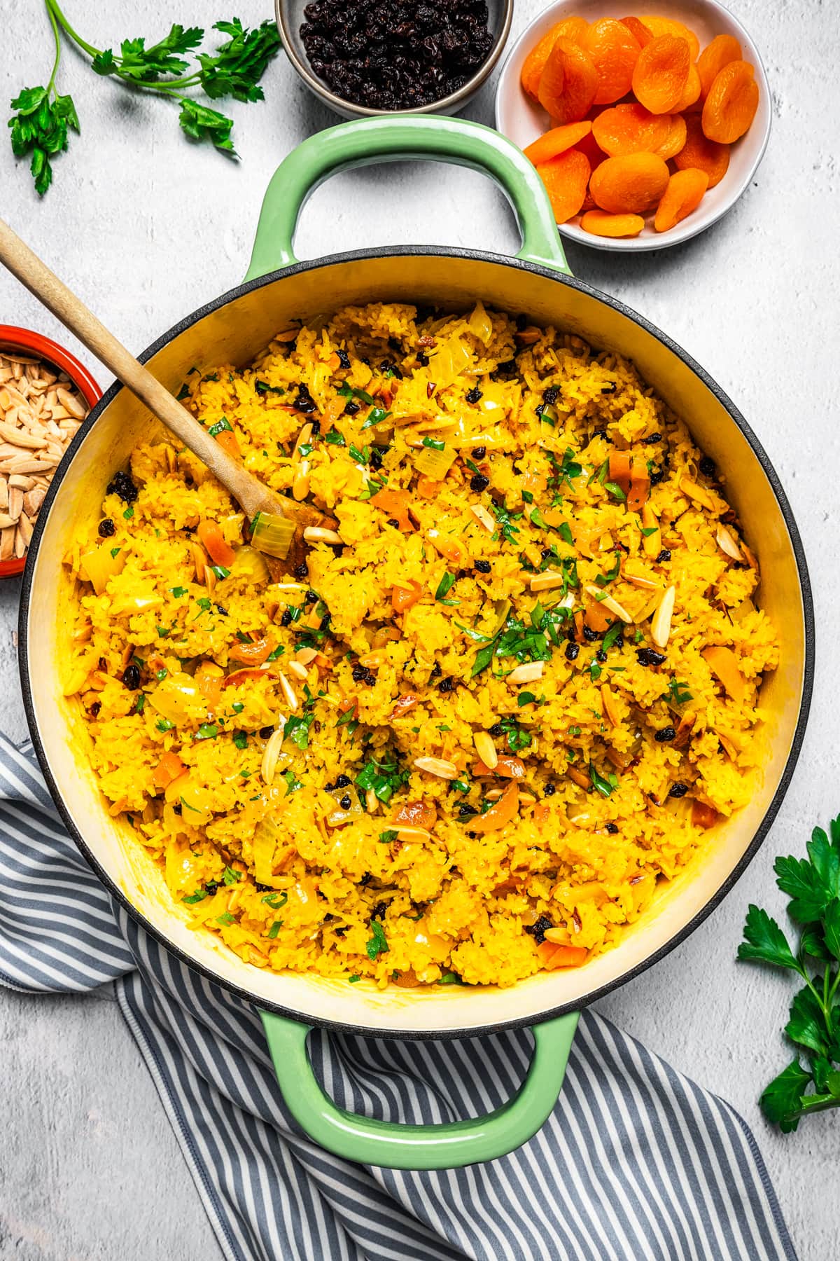 Mediterranean rice in a Dutch oven near dried apricots, currants, and slivered almonds.