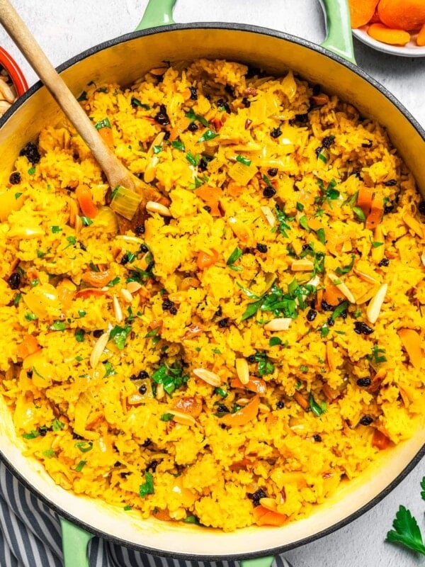 Mediterranean rice in a Dutch oven near dried apricots, currants, and slivered almonds.