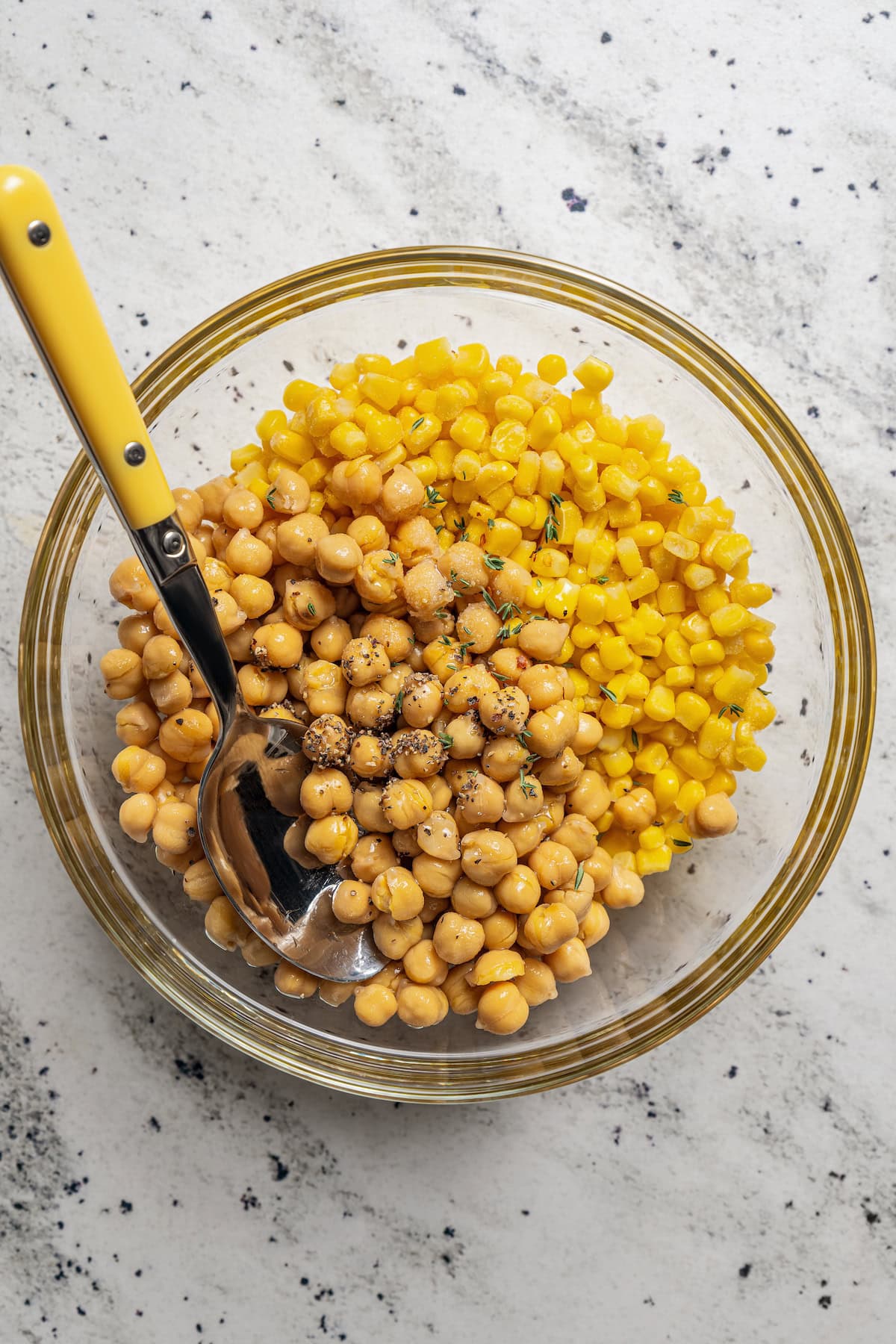 Seasoning corn and garbanzo beans before roasting them.