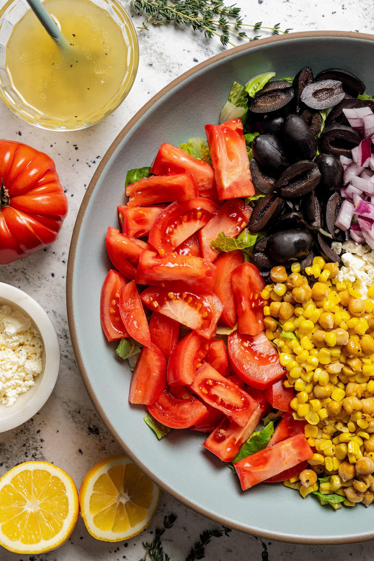 Combining the ingredients for Mediterranean salad in a salad bowl.