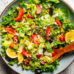 Mediterranean salad in a salad bowl with tongs.