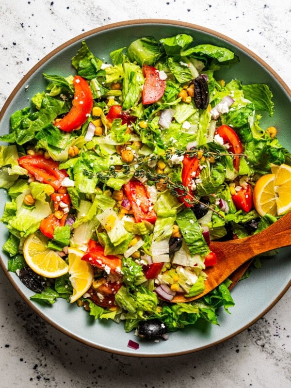 Mediterranean salad in a salad bowl with tongs.