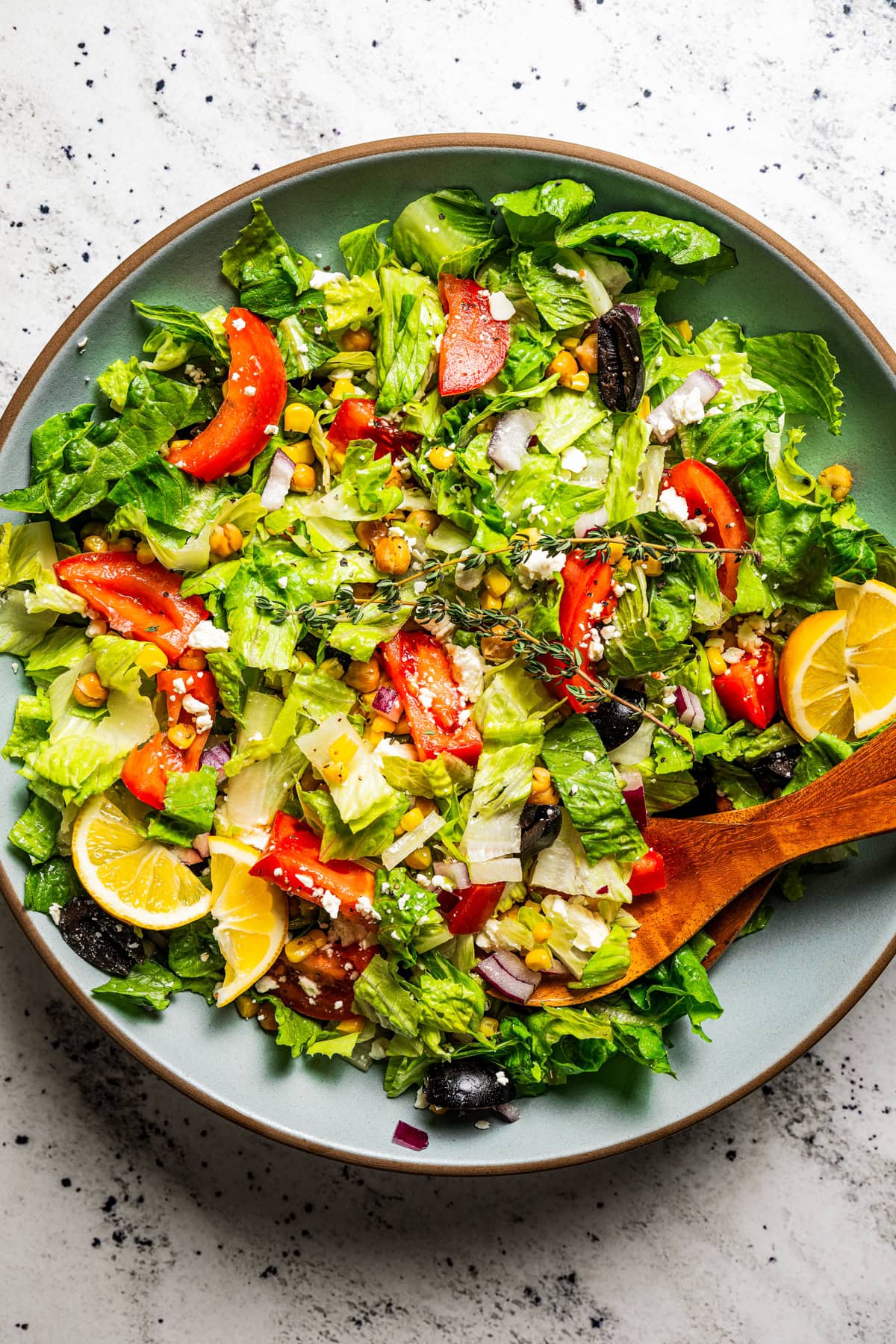 Mediterranean salad in a salad bowl with tongs.