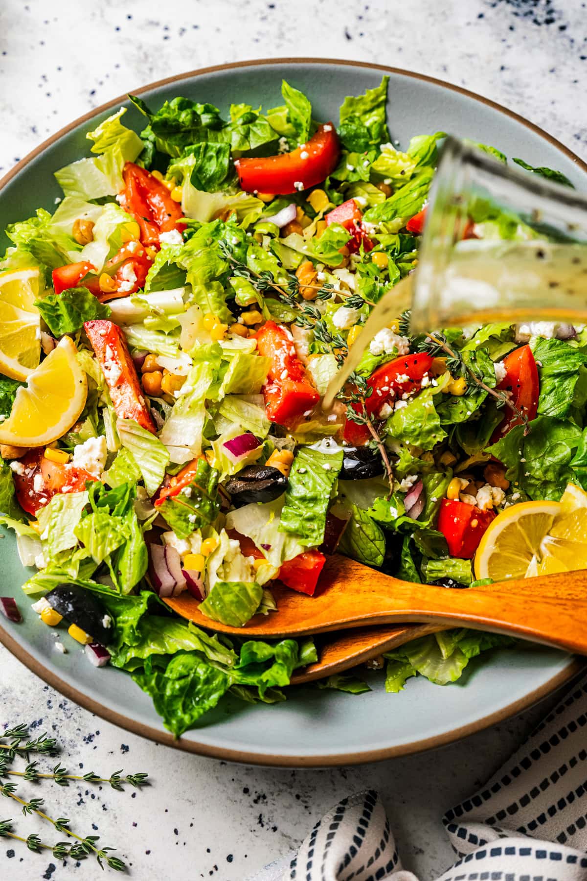 Pouring lemon dressing over a salad.