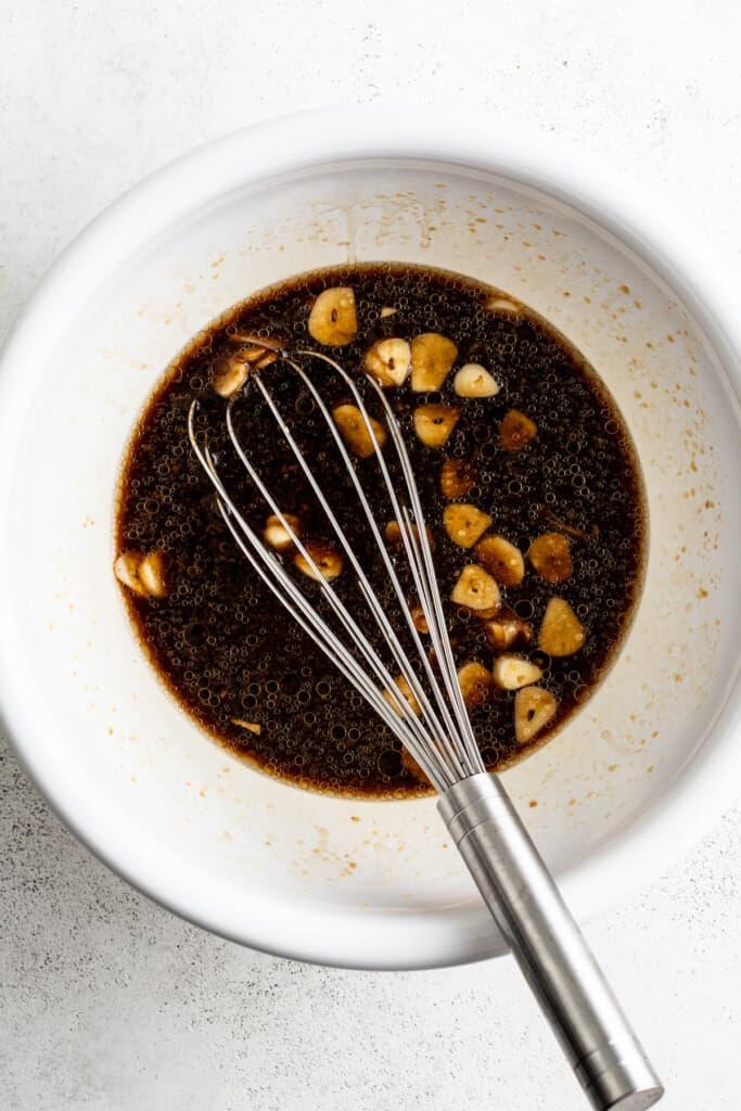 Asian marinade in a bowl with a whisk.