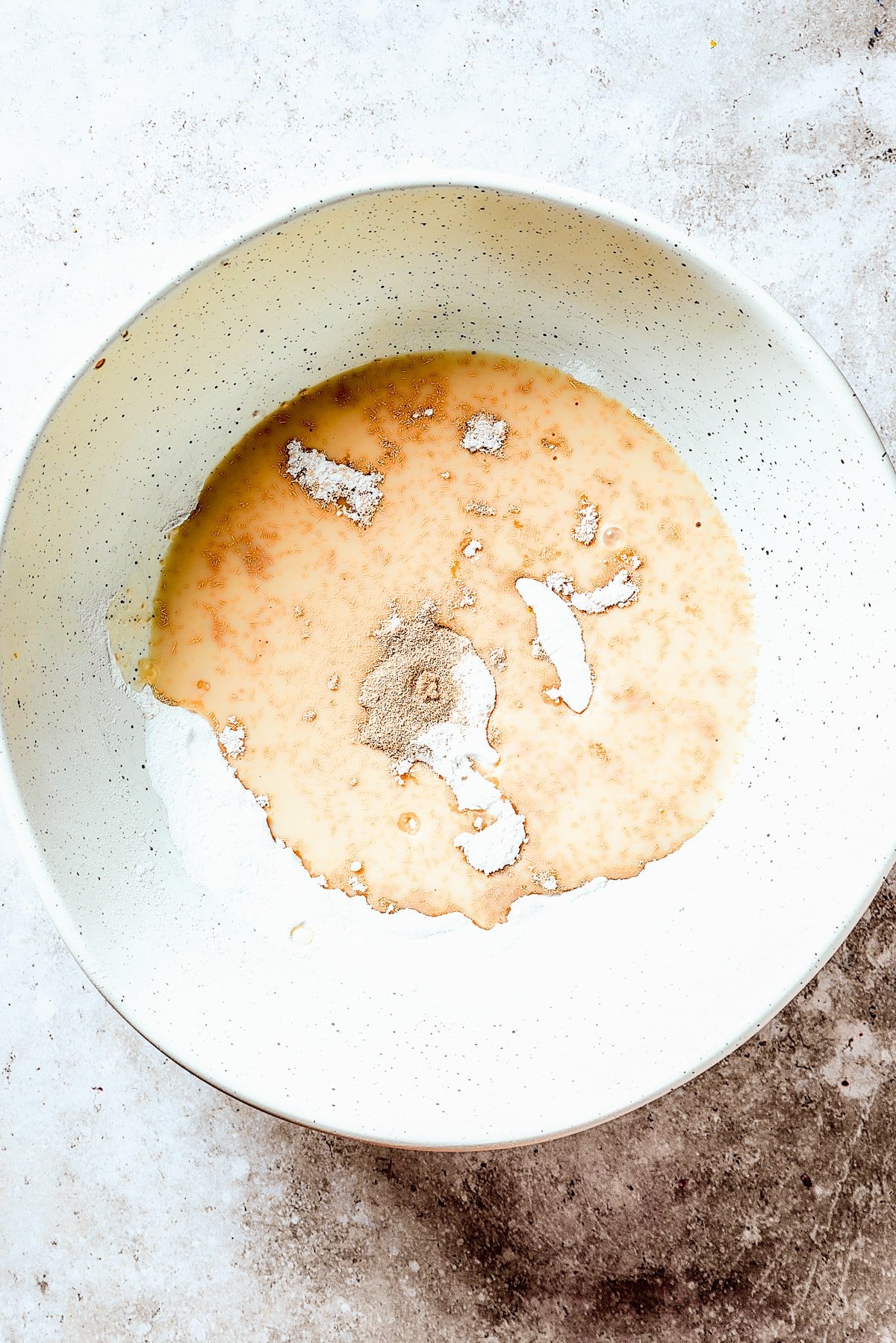 Combining warn water, yeast, flour, and salt to make skillet bread.