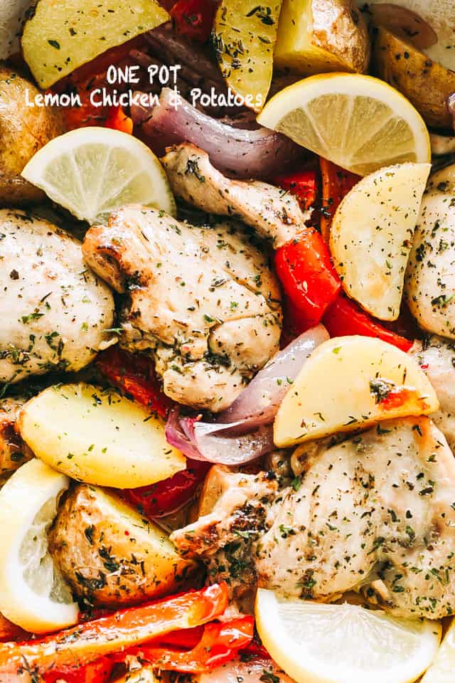 Marinated lemon chicken and potatoes with red bell peppers, onions, and lemon wedges as a garnish. 