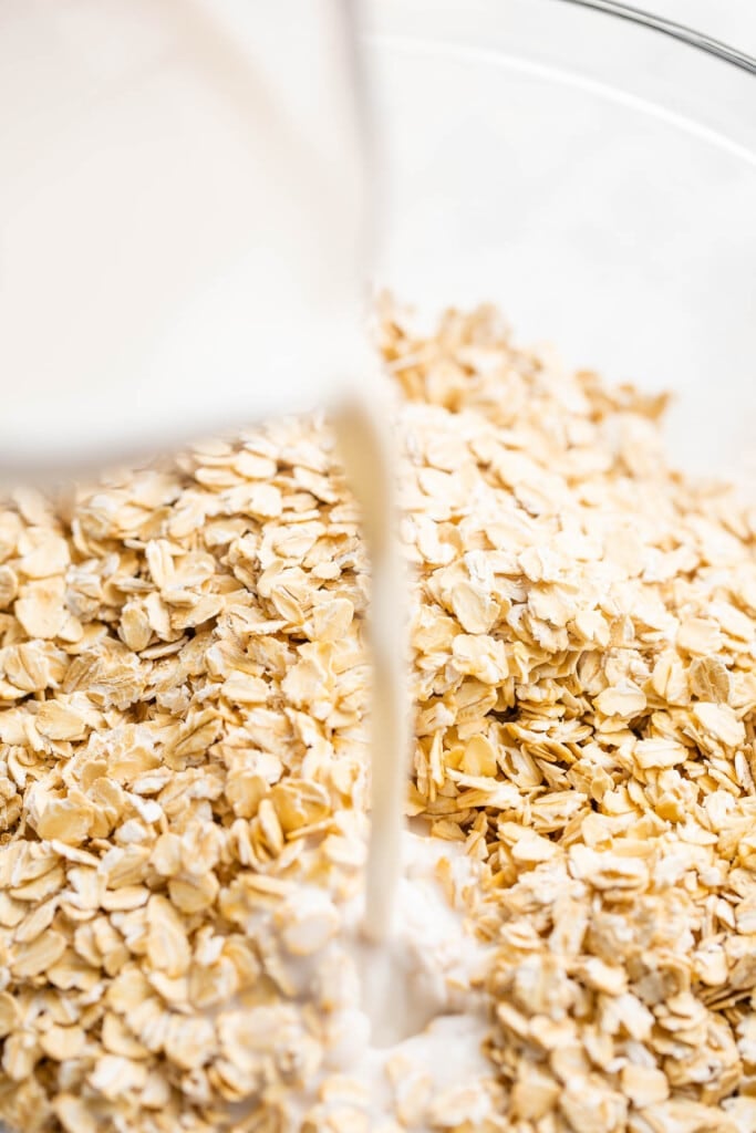 Pouring milk over oats.