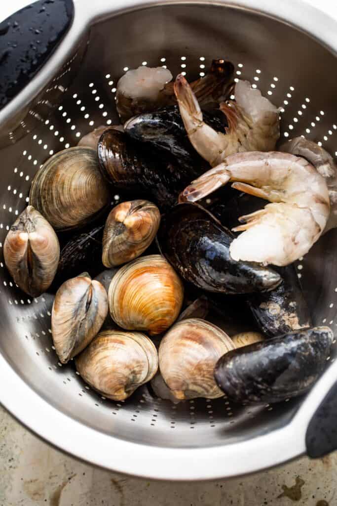 Shrimp, clams, and mussels in a colander.