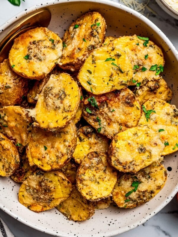 Close-up image of a bowl filled with parmesan potatoes.