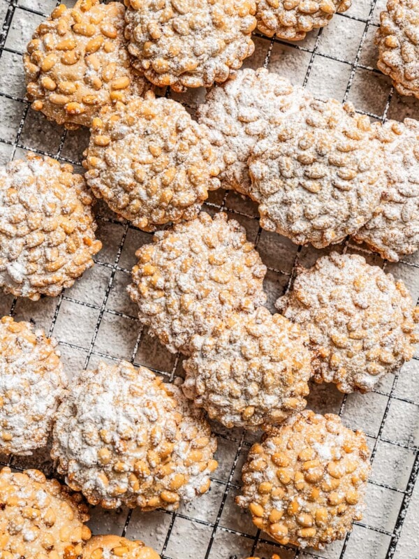 Baked pignoli cookies dusted with powdered sugar.