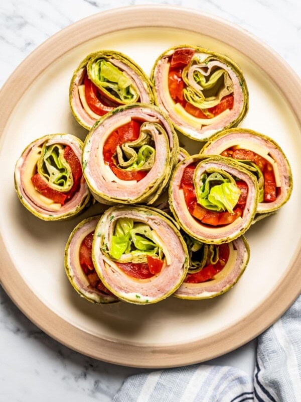 Overhead image of pinwheel sandwiches arranged on a serving plate.