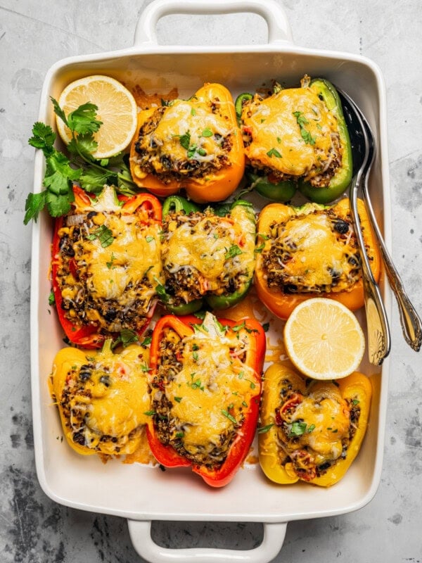 Quinoa stuffed peppers arranged in a baking dish.