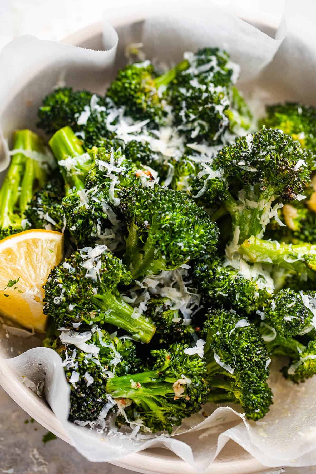 air fryer roasted broccoli served in a bowl and topped with parmesan cheese