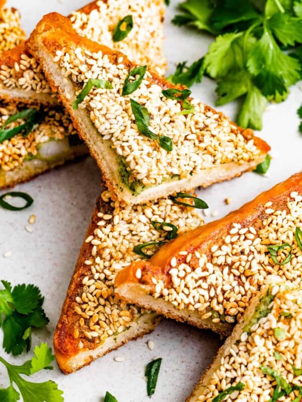 Overhead photo of shrimp toast triangles garnished with cilantro and scallions.