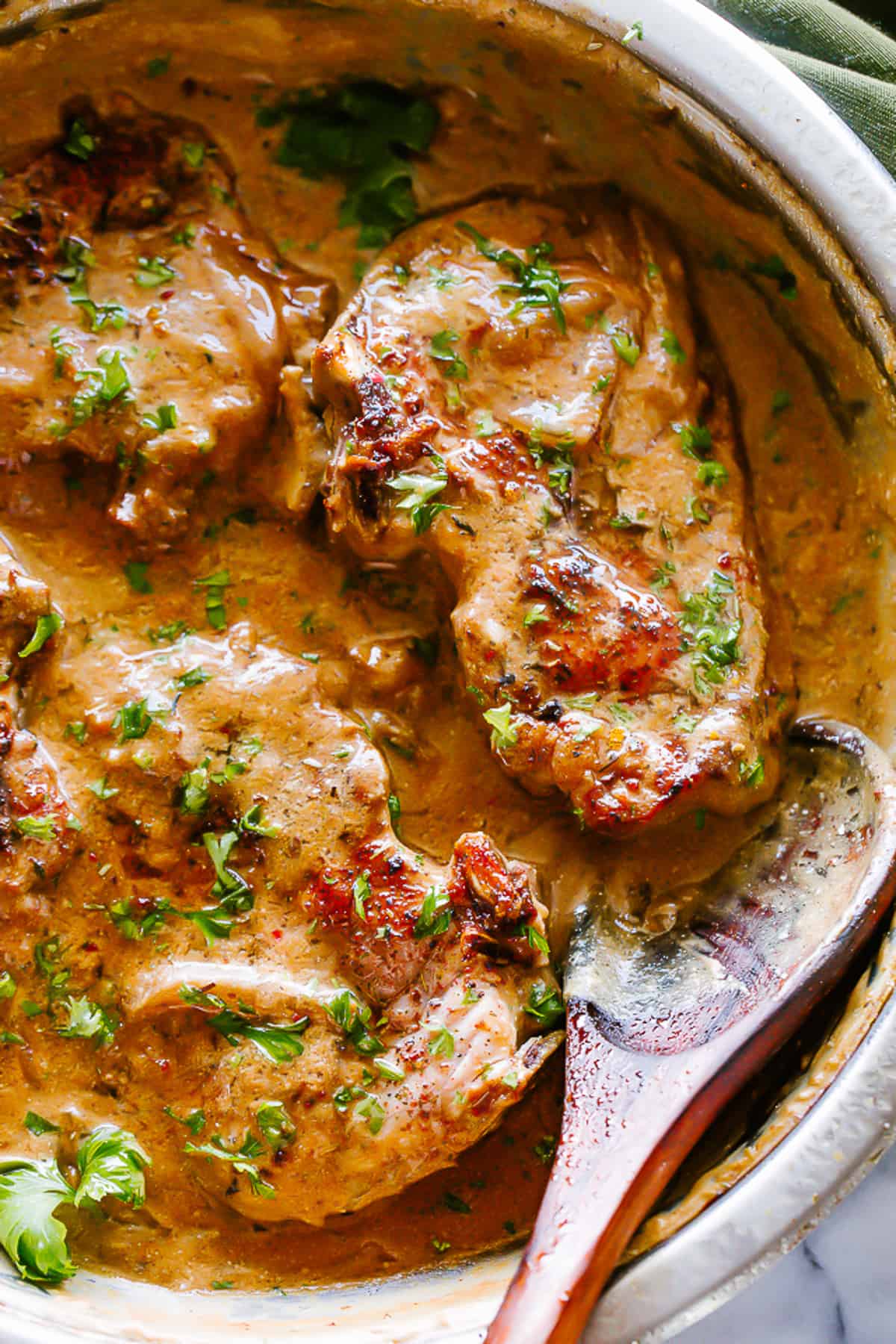 Pork chops cooking in onion gravy.