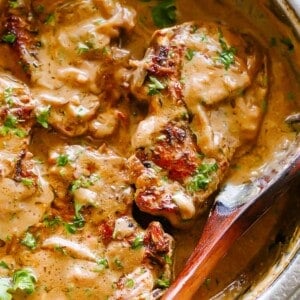 Overhead shot of smothered pork chops with onion gravy in a skillet.