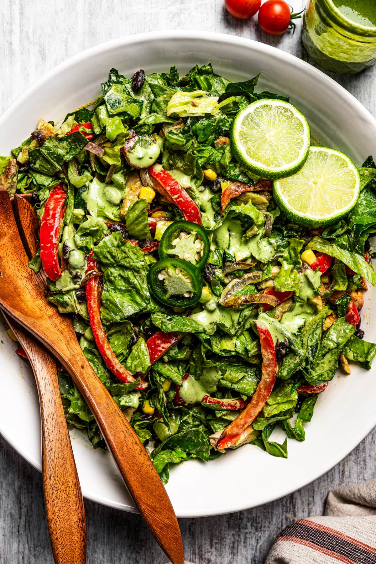 Southwestern chicken salad in a salad bowl with serving tongs.