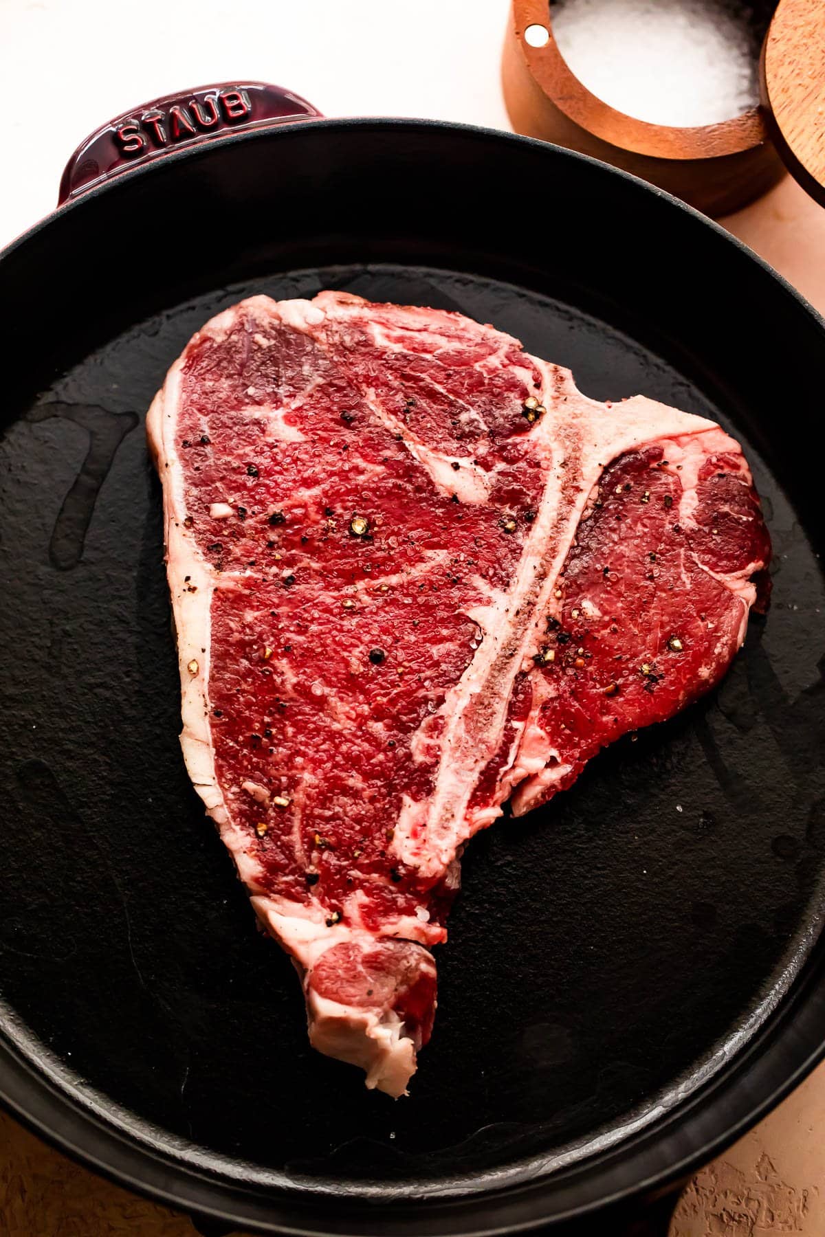 Raw t-bone steak in a skillet