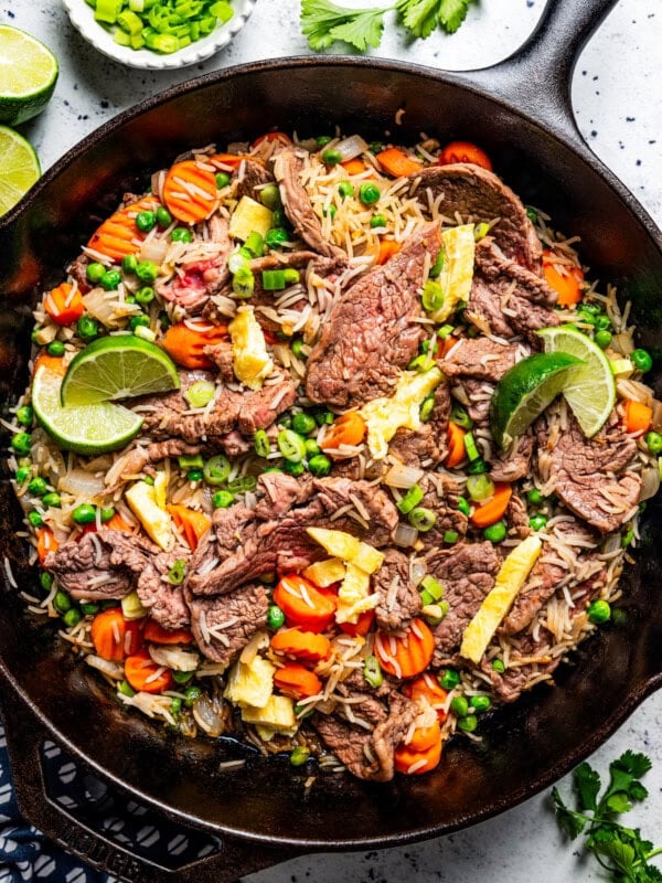 Cooked steak fried rice in a black cast iron skillet.