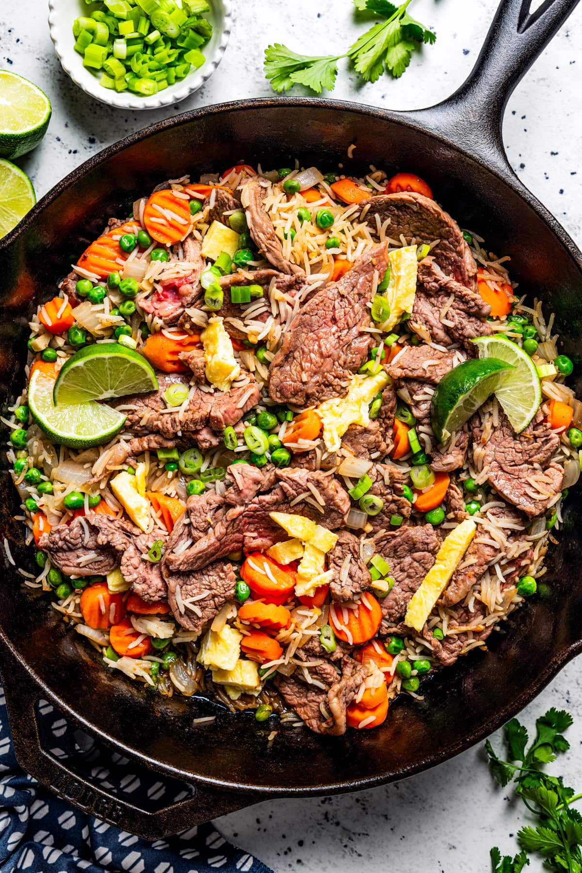 Cooked steak fried rice in a black cast iron skillet.