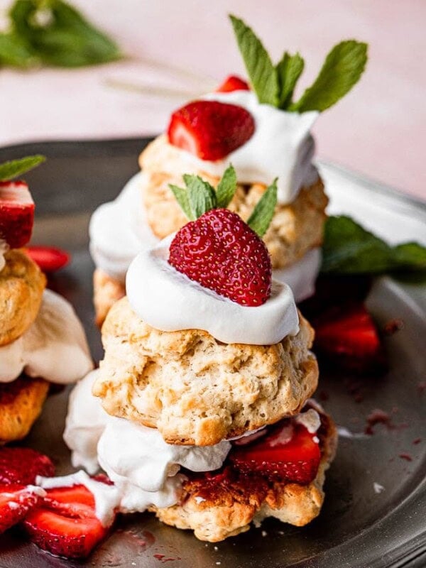 Strawberry shortcake served on a dark platter.