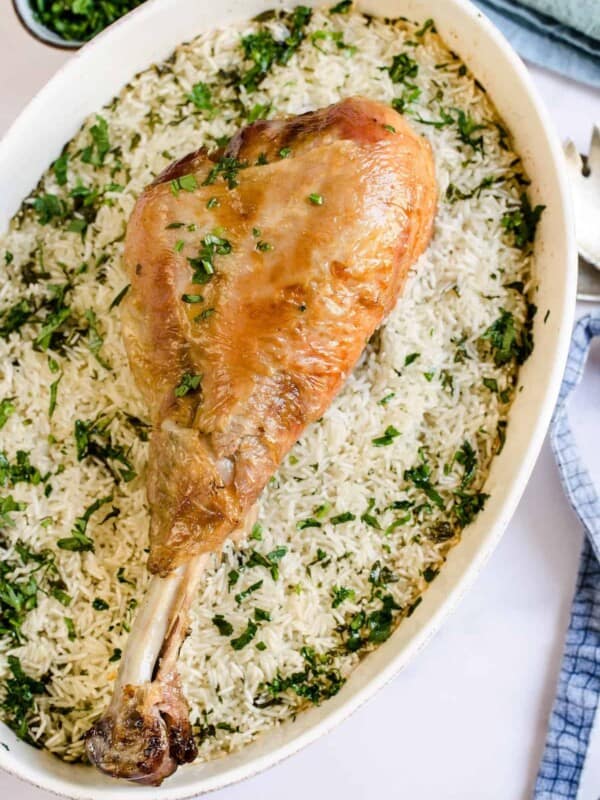 A large turkey leg over a bed of rice.