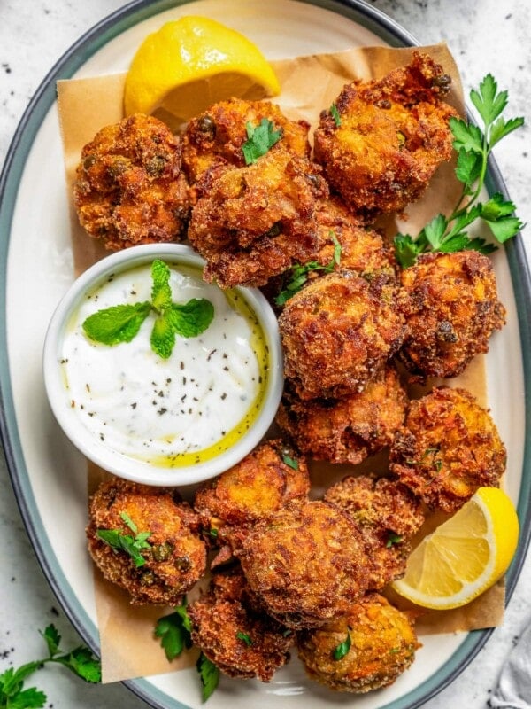 Vegetarian Meatballs arranged on an oval platter, with a white dipping sauce in a bowl.